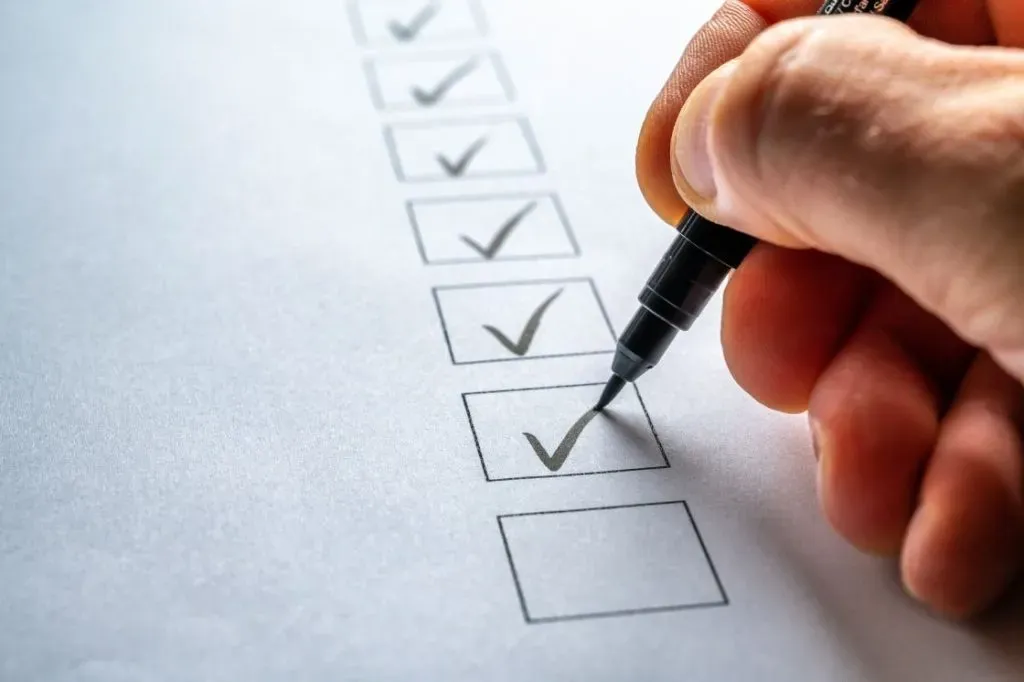 A hand holding a cleaning checklist, ticking off a completed task