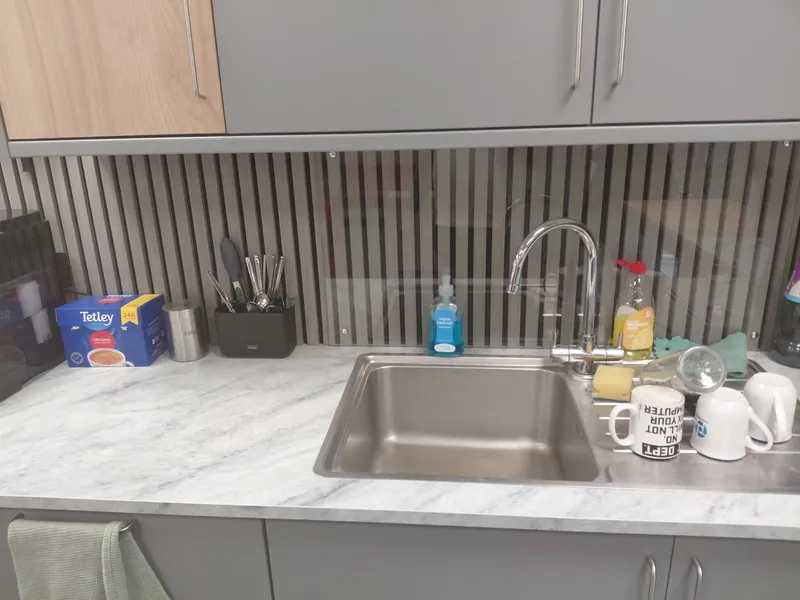 Stainless steel office kitchen sink with tap, drainer and mugs