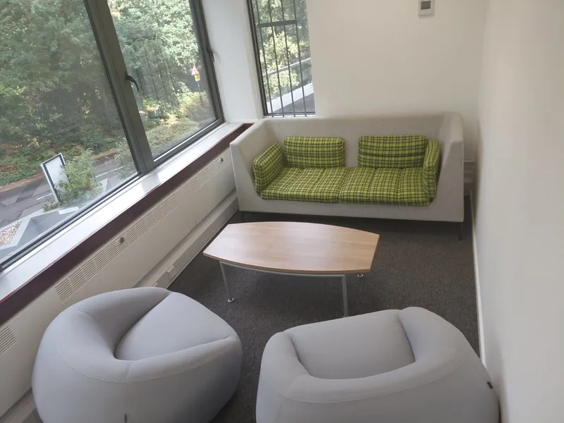 Green office sofa and two grey armchairs beside a low table